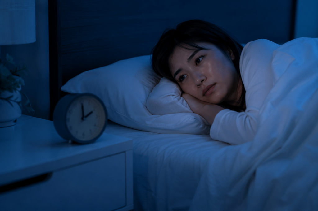 夜中に目が覚めて時計を見る女性